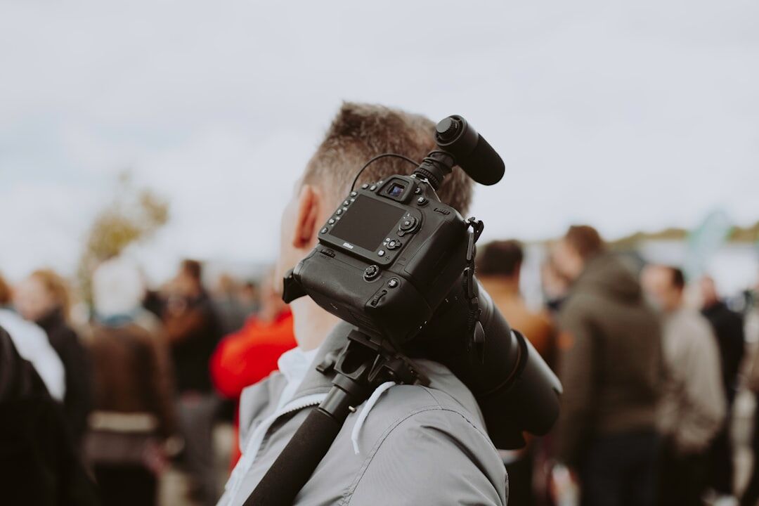 Cameraman filming a live outdoor event with a professional camera